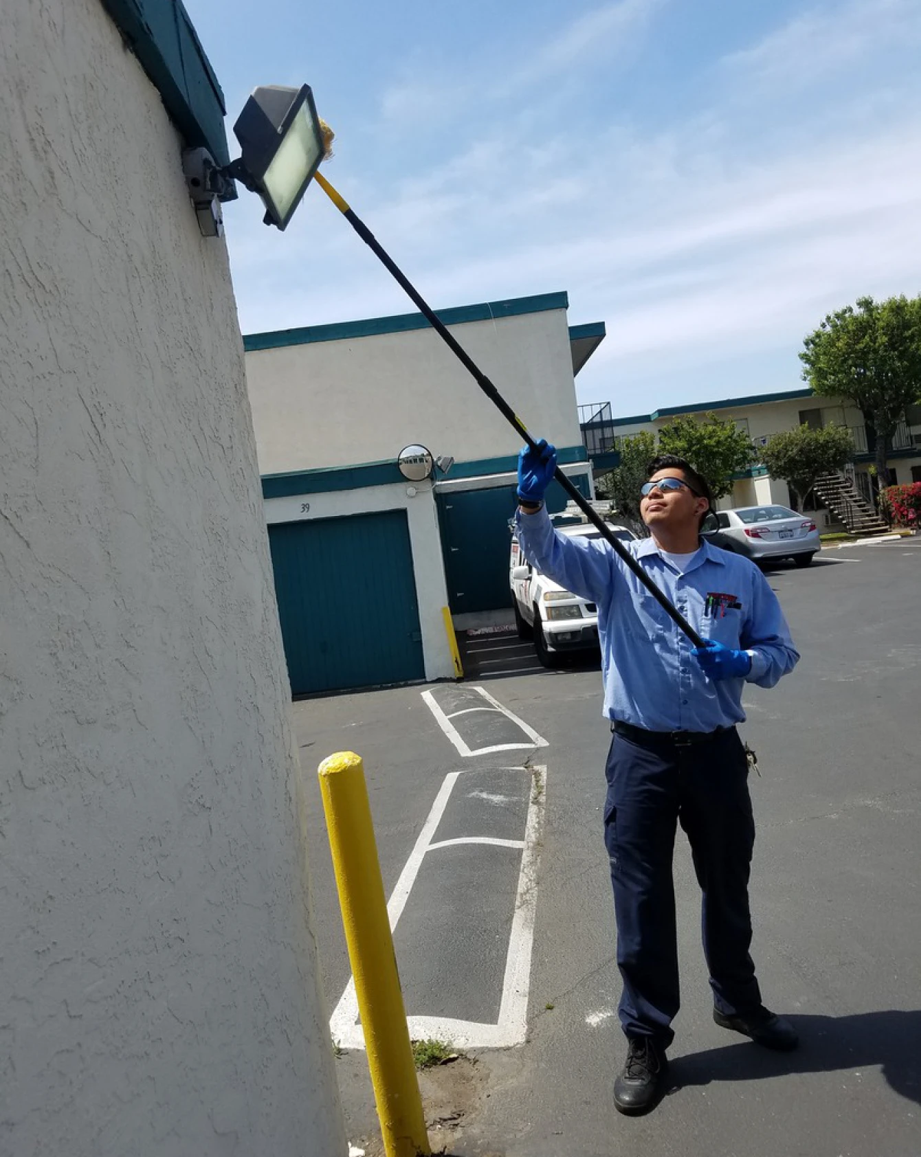 Worker cleaning outdoor light fixture